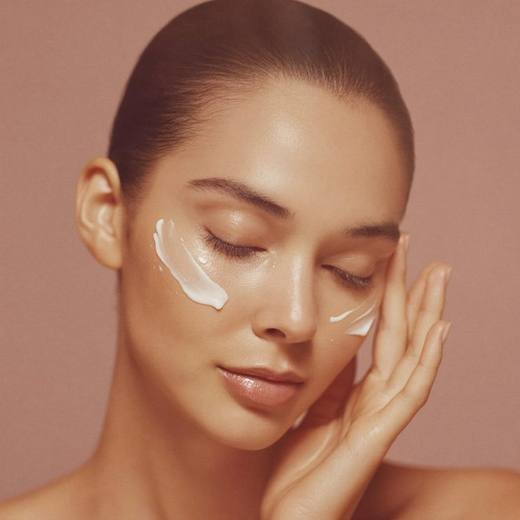 Woman applying Maison Djennah Beauty skincare to her face