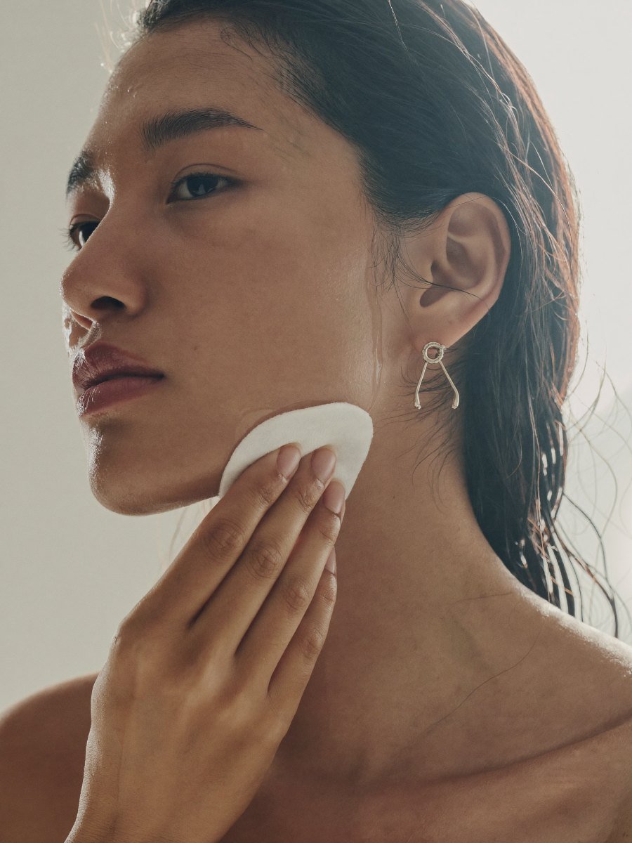 Sweeping a cotton pad along the jawline