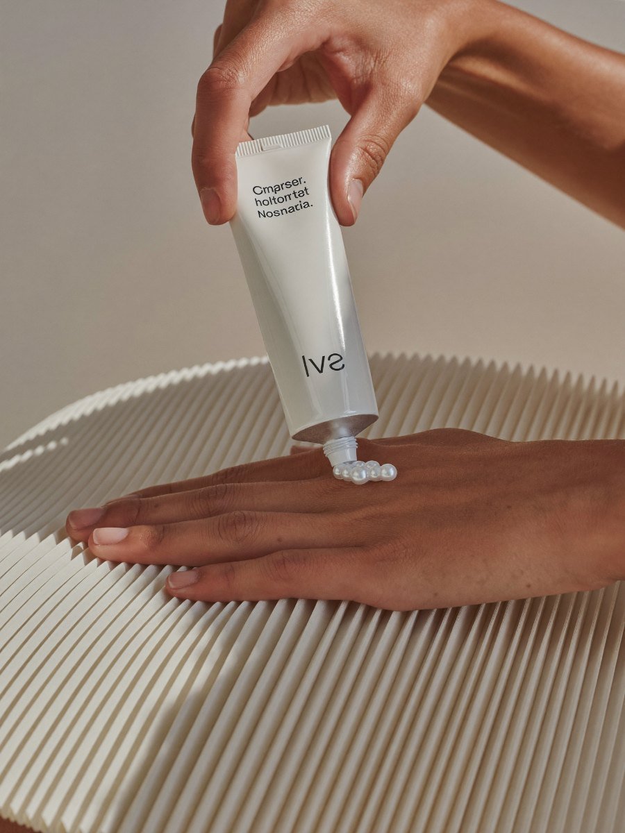 Pressing cream from the tube onto the back of the hand